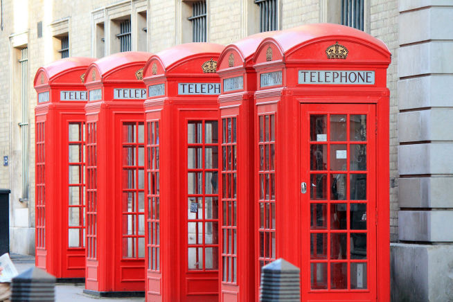 five red phone boxes in London street during student trip to London