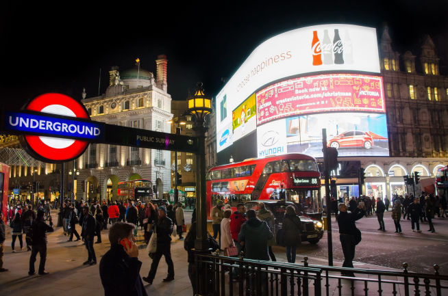 students leaving London underground station exit at night 